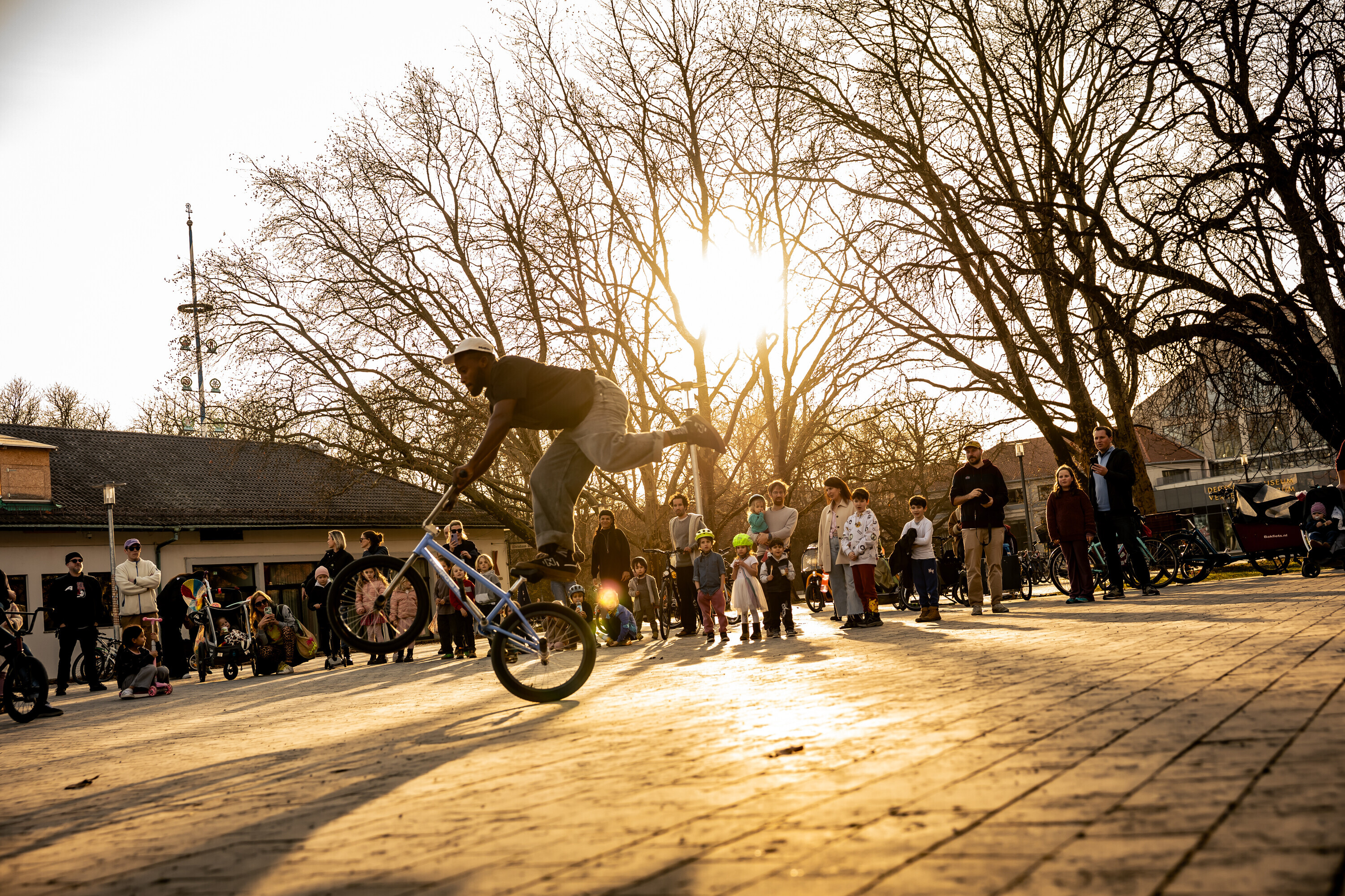 Omari Cato f&uuml;hrt auf einem st&auml;dtischen Platz vor Zuschauern Flatland-BMX-Tricks vor.